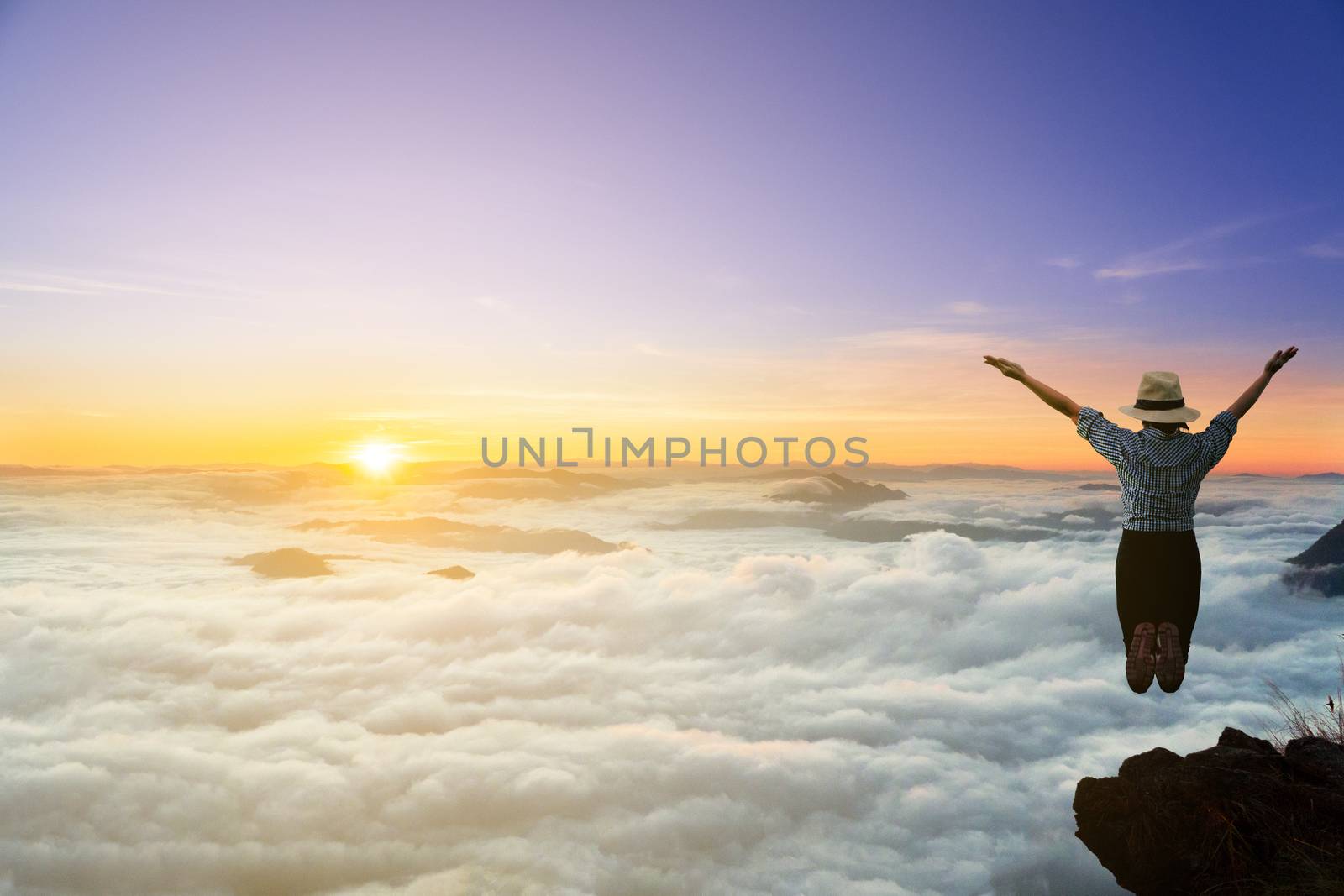 The rural girl jumped happy after climbing onto the top of the hill.