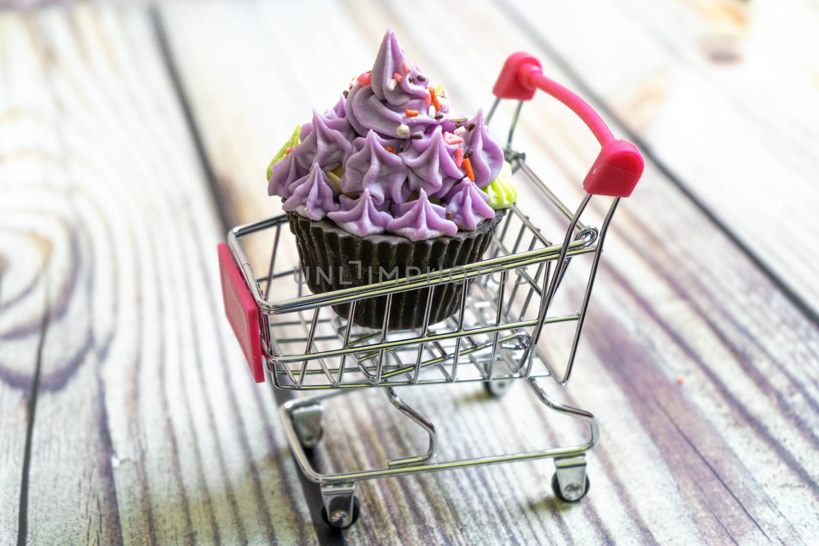 beautiful cupcake dessert sweet soap placed in a shopping cart on a wooden background. Shows hobbies and skills that people are learning in the pandemic. Shot with copyspace for text
