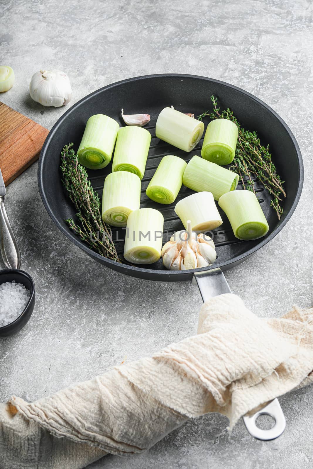 Raw braised Leek sultan on grill pan uncooked with herbs ingredients , on grey textured background side view. by Ilianesolenyi