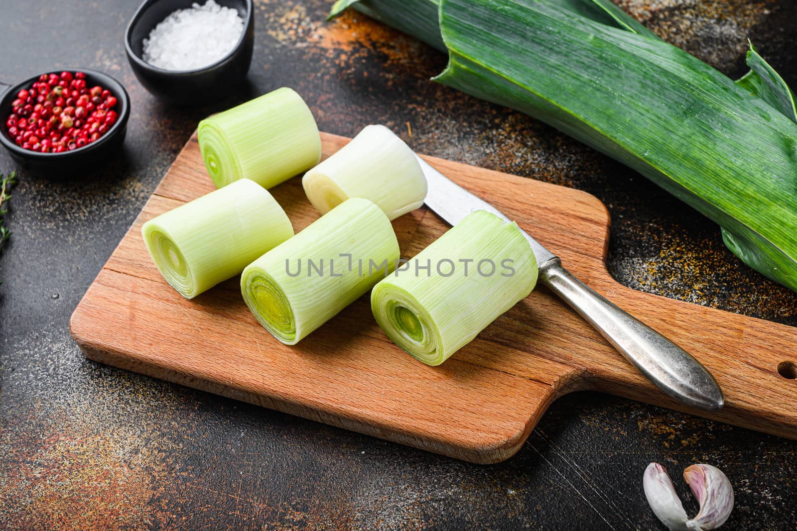 Chopped leek for cooking Braised Leeks with herbs ingredients , on rustic metall background dark, side view
