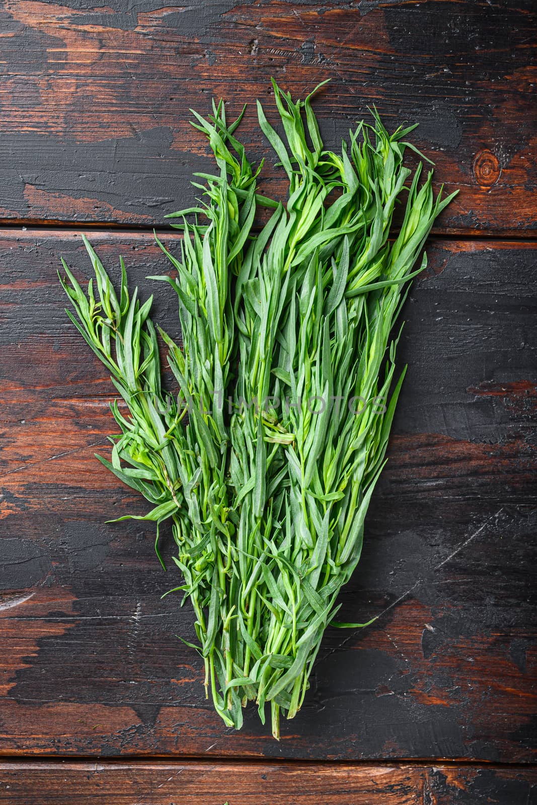 Raw fresh tarragon bunch, on old wooden background, top view