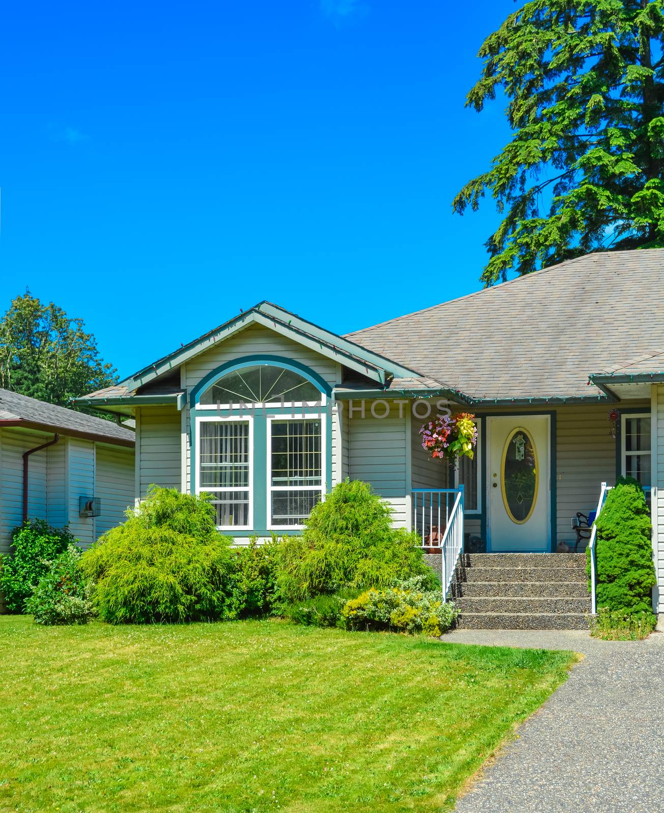 A perfect neighbourhood. Main entrance of nice residential house with green lash lawn on the front yard