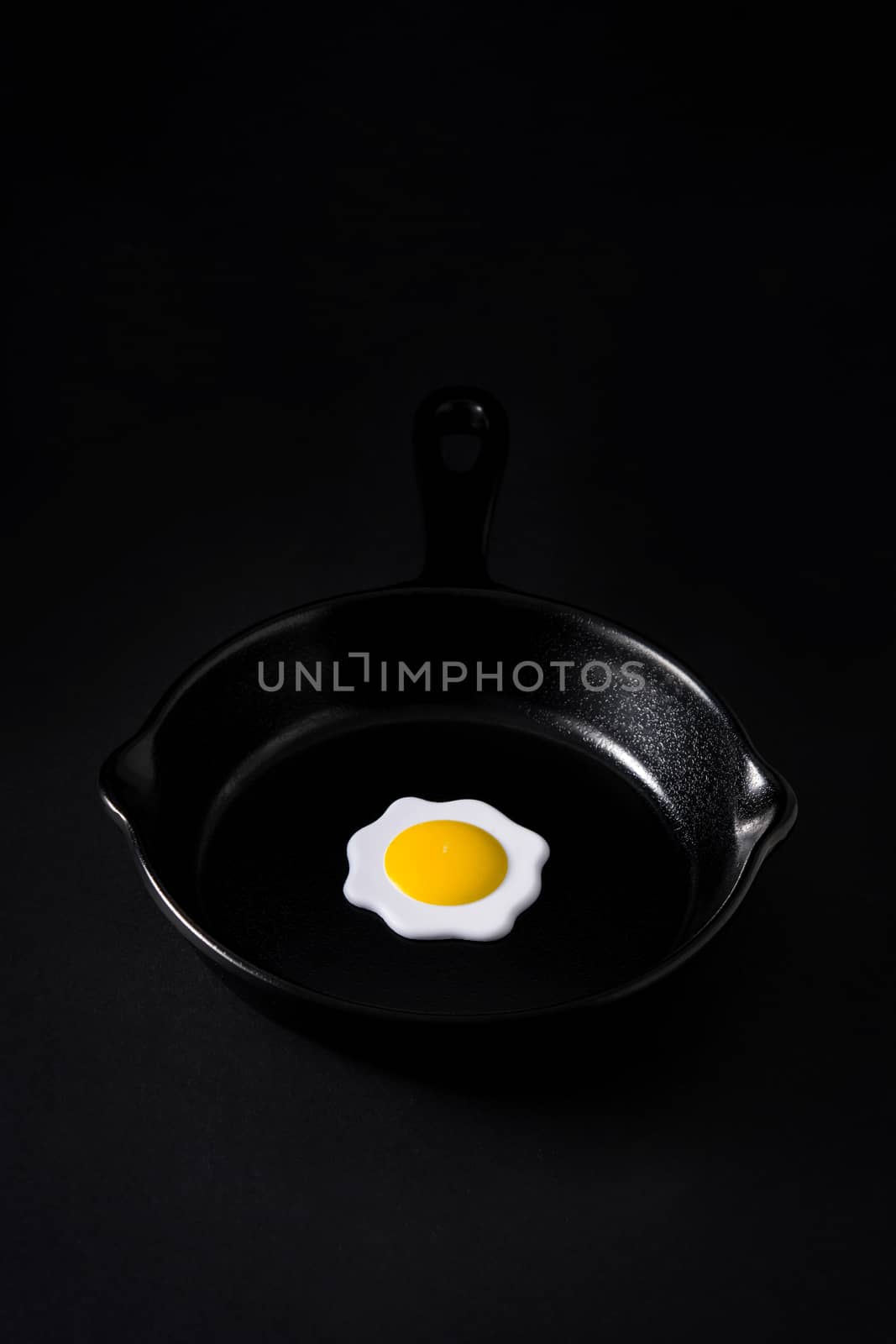 Black frying pan with egg inside by chandlervid85