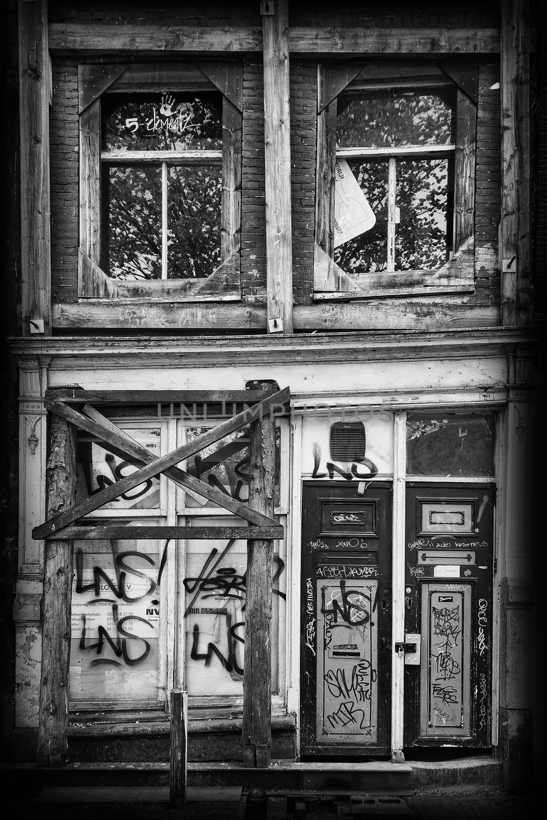 Old derelict abandoned canal house in the city of Amsterdam Holland  black and white, monochrome image