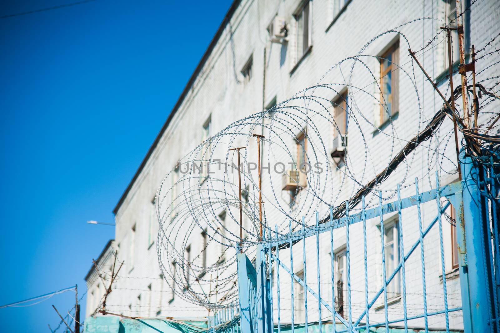 Barbed wire fence stretched around prison walls