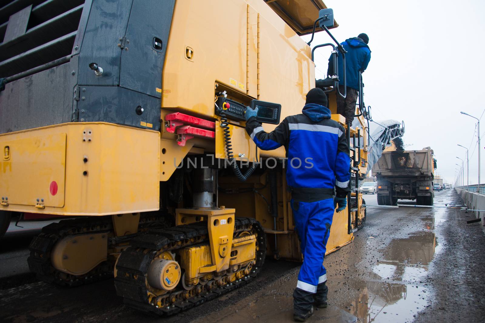 Repair of asphalt pavement of the road. Road cold milling machine removes the old asphalt and loading into a dump truck