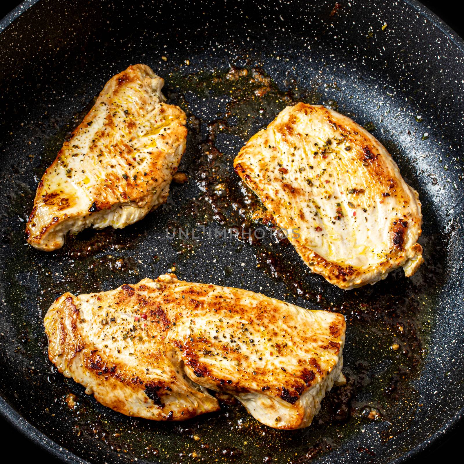 Turkey steak grilled in a pan. The cooking process.