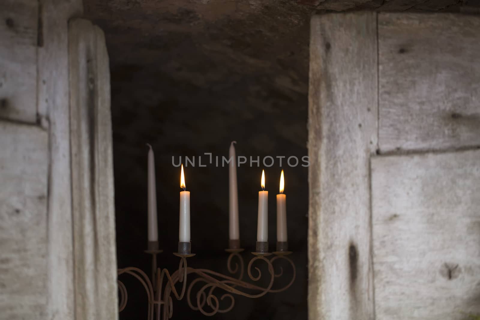 Candle sticks with candlelight in the entrance to a vaulted cellar