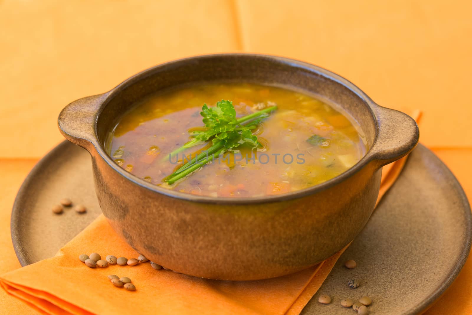 Bowl of lentil soup with vegetables and parsley