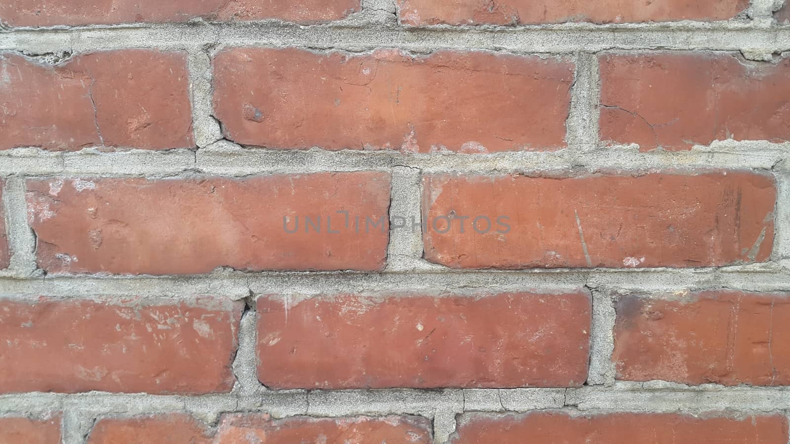 Closeup texture of red brick wall. A background of a weathered old exterior brick wall in the sunshine.