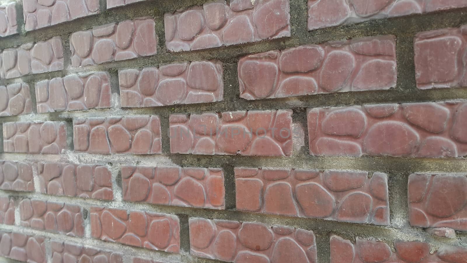 Closeup texture of red brick wall. A background of a weathered old exterior brick wall in the sunshine.