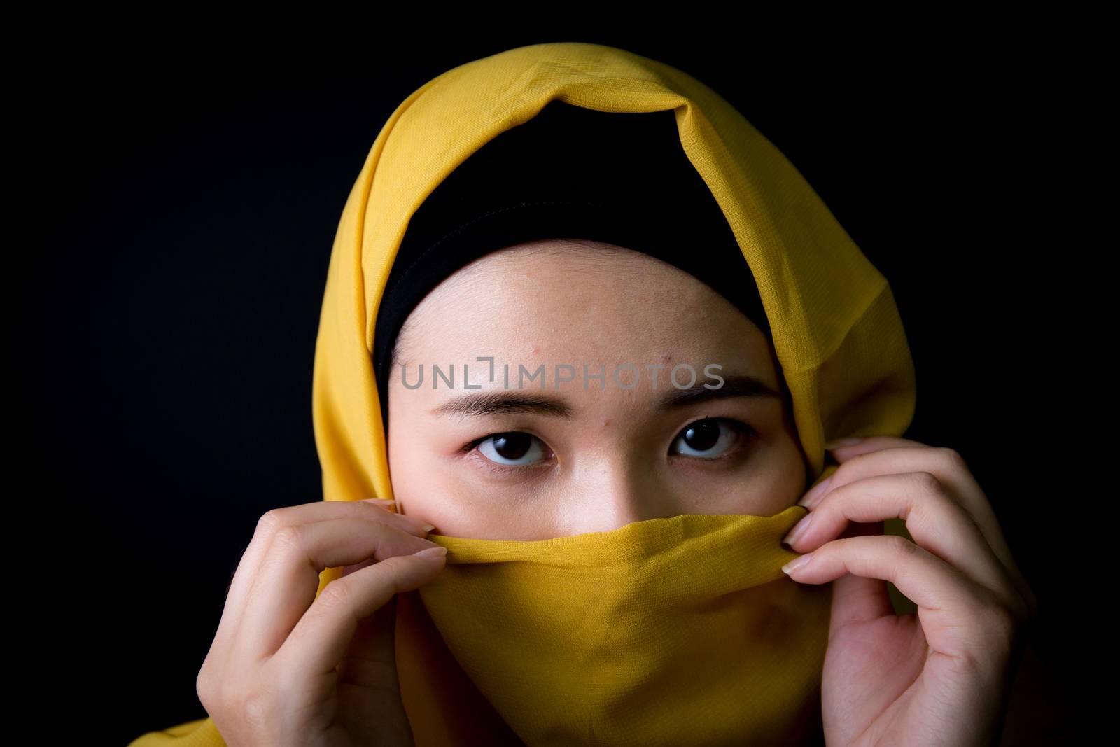 beautiful mysterious young woman wearing scarf close up.