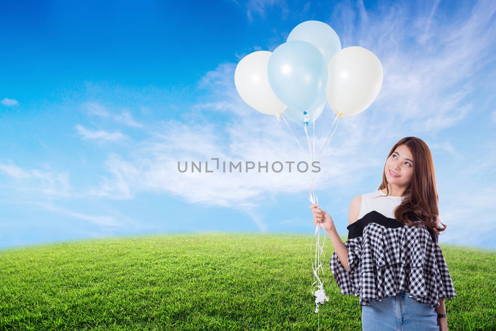 Young woman holding balloons on meadow summer with freedom lifestyle concept.