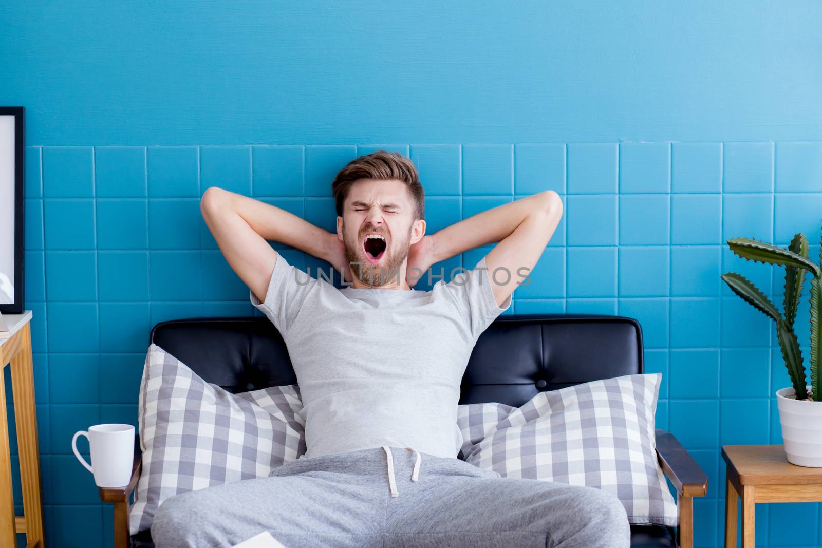 man yawning and going asleep in his  living room