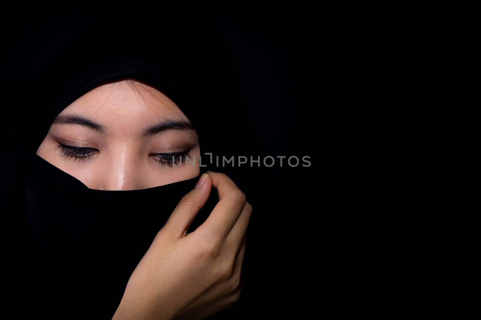beautiful mysterious young woman wearing scarf close up.