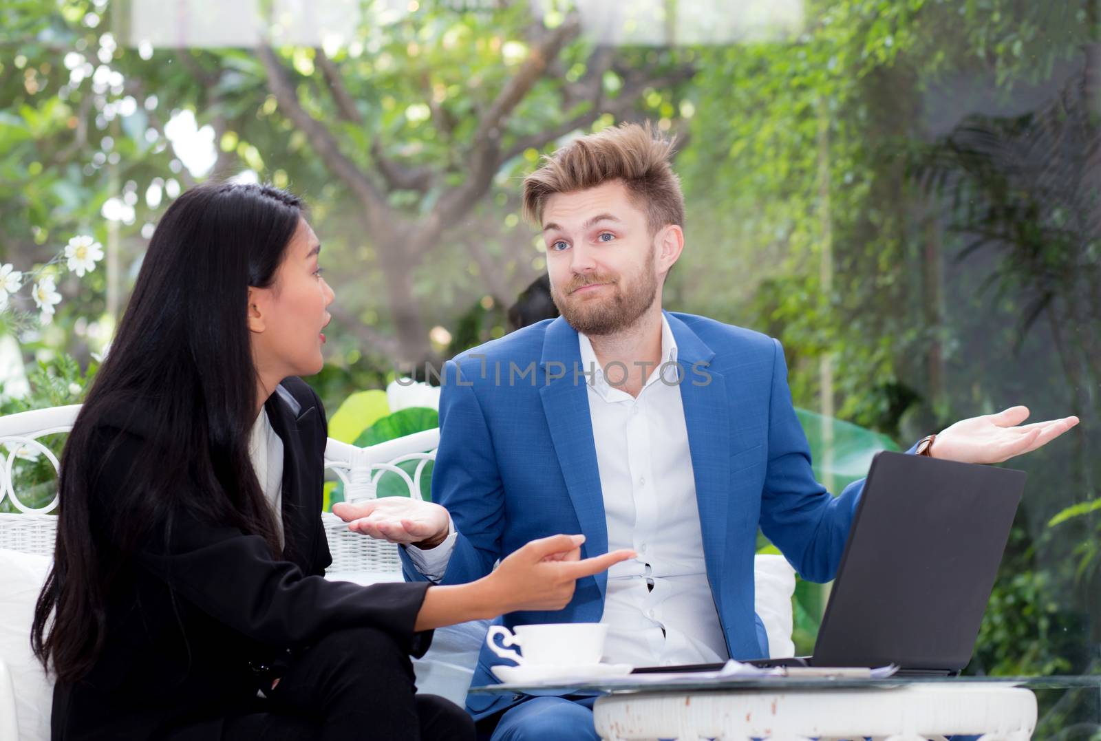 technology and office concept - two business man and woman with laptop - tablet pc computer and papers having discussion in office.