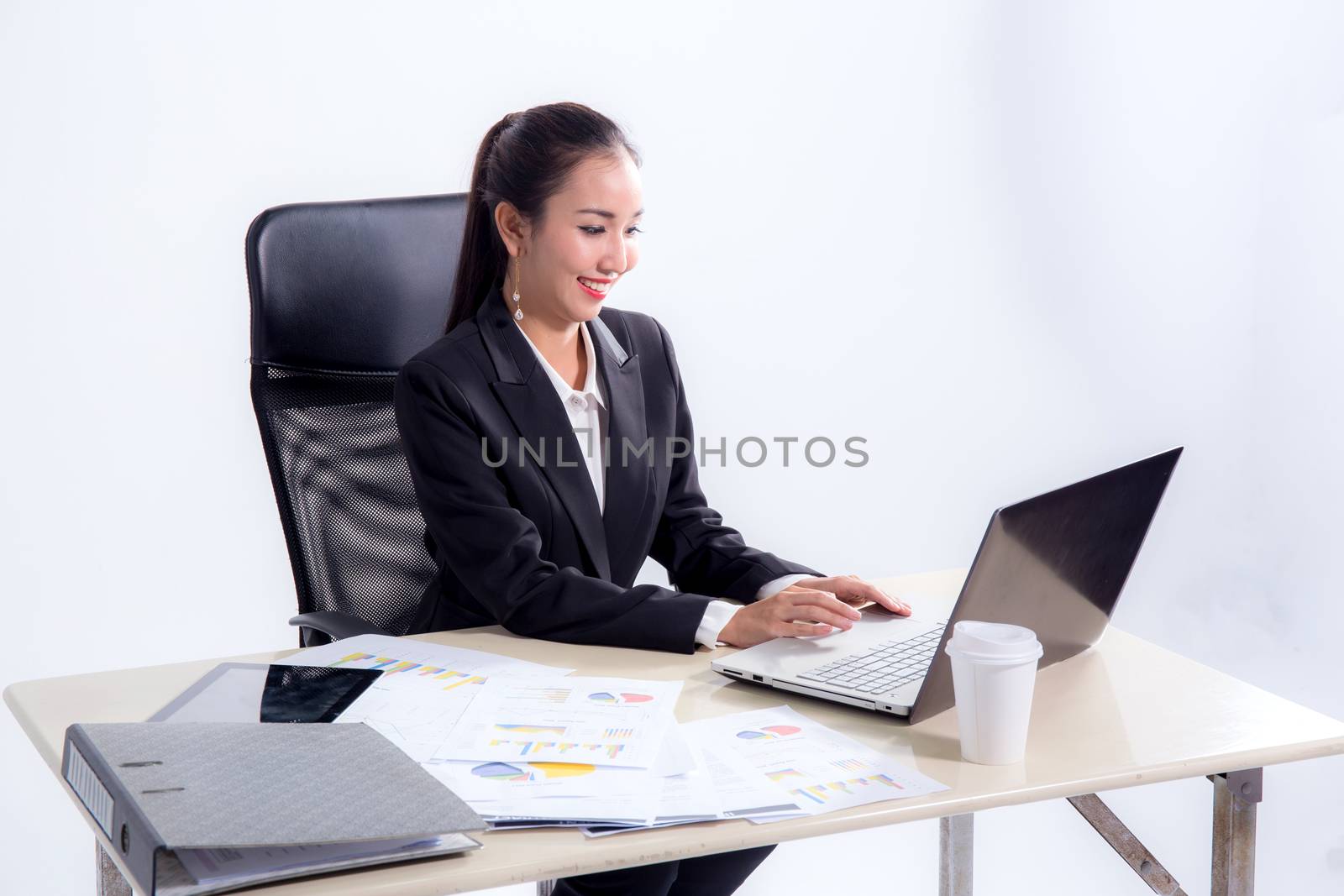 Young businesswoman working in office, typing, using computer. Concentrated woman searching information online