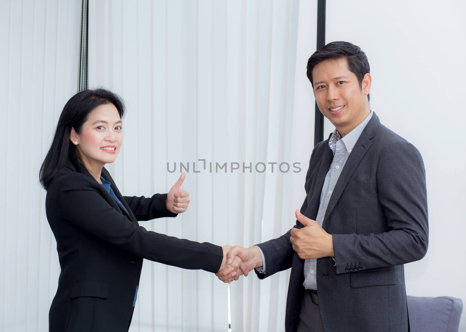 Handshake of businessman and businesswoman after successful business meeting.