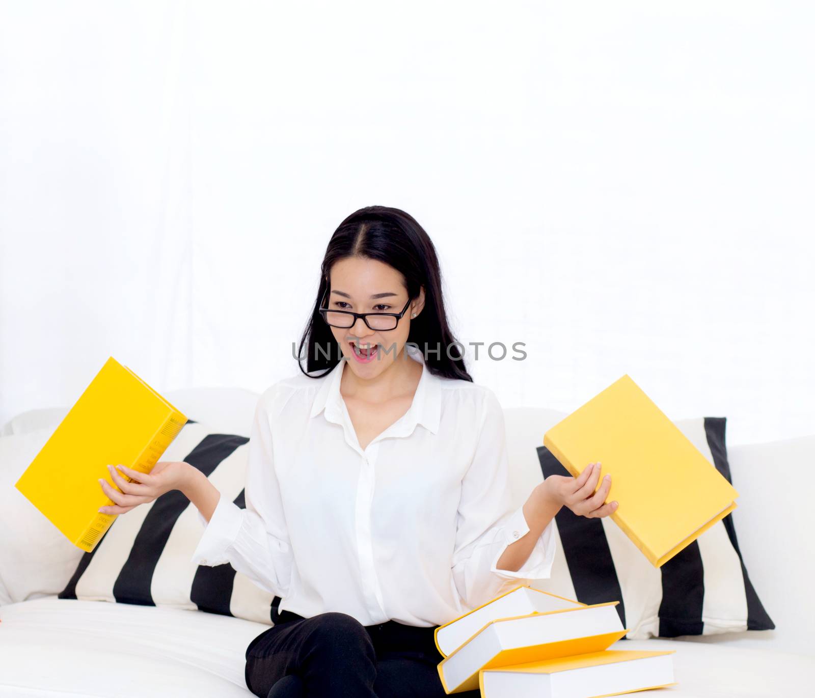 portrait of a beautiful young female student with not want read book on sofa in living room - education concept.