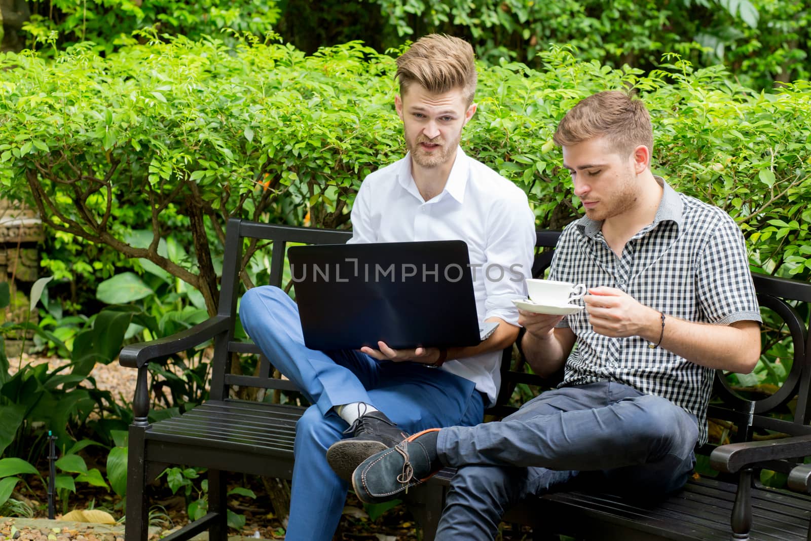 Two business people use of the notebook computer at outdoor