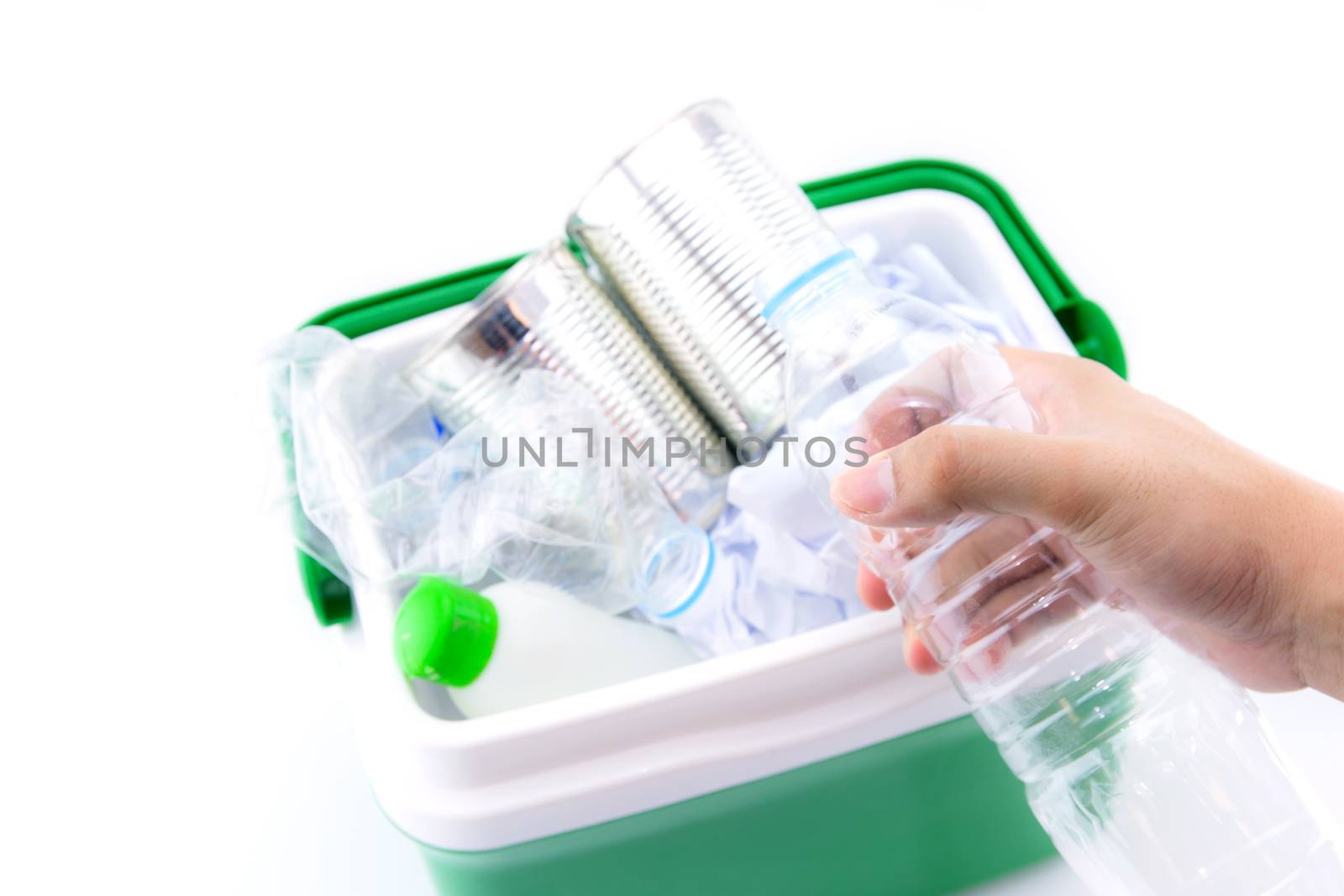 A recycle bin with plastic bottles, paper and other plastic items  and bottle on hand isolated on white background.