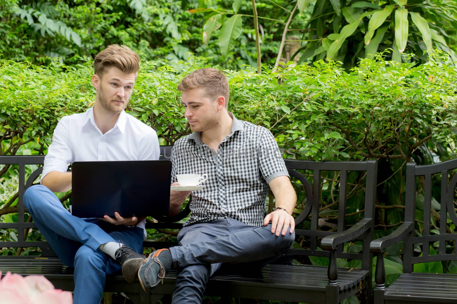 Two business people use of the notebook computer at outdoor