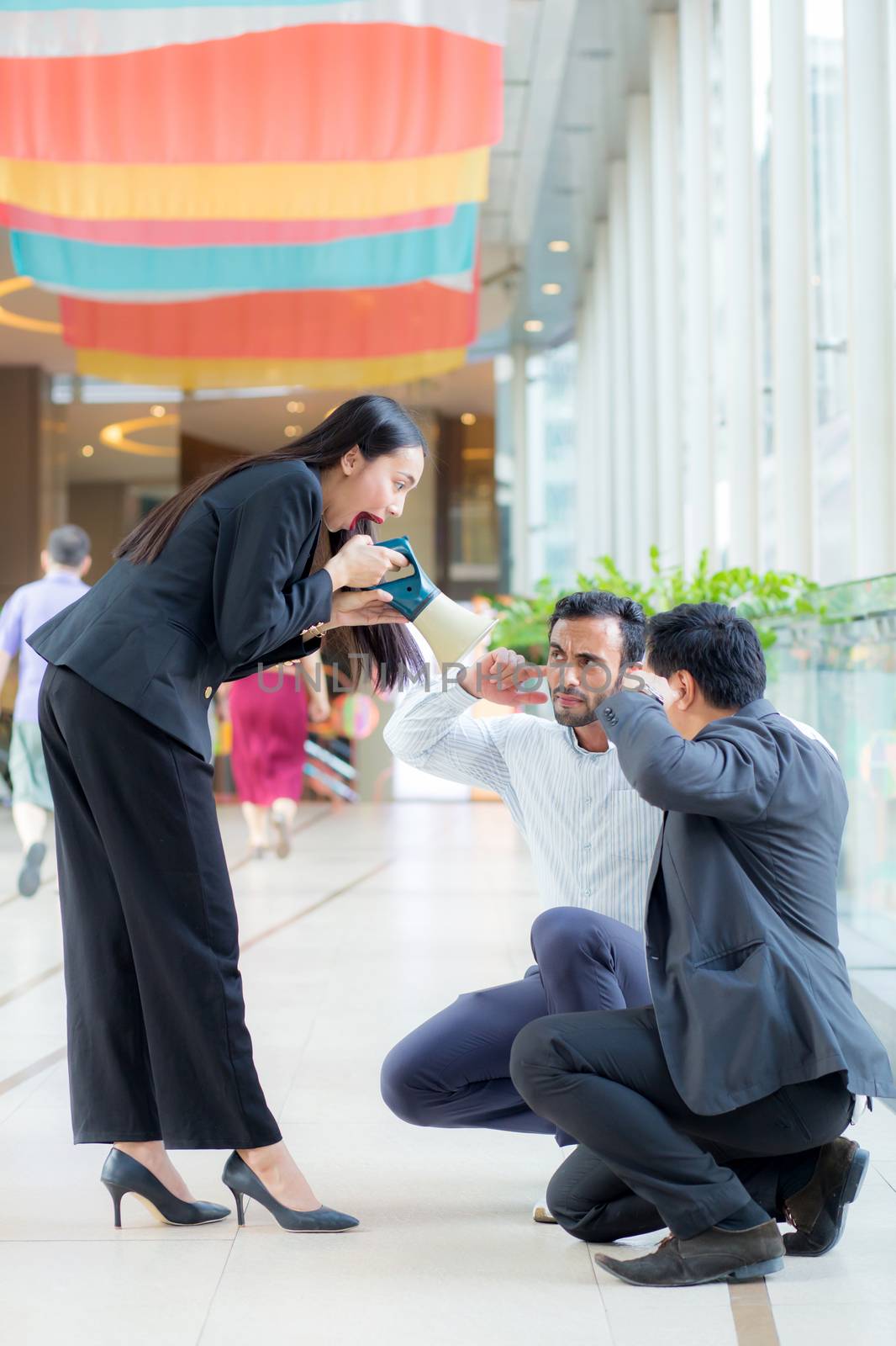 Young business woman working at the office, 
shouting and yelling in megaphone