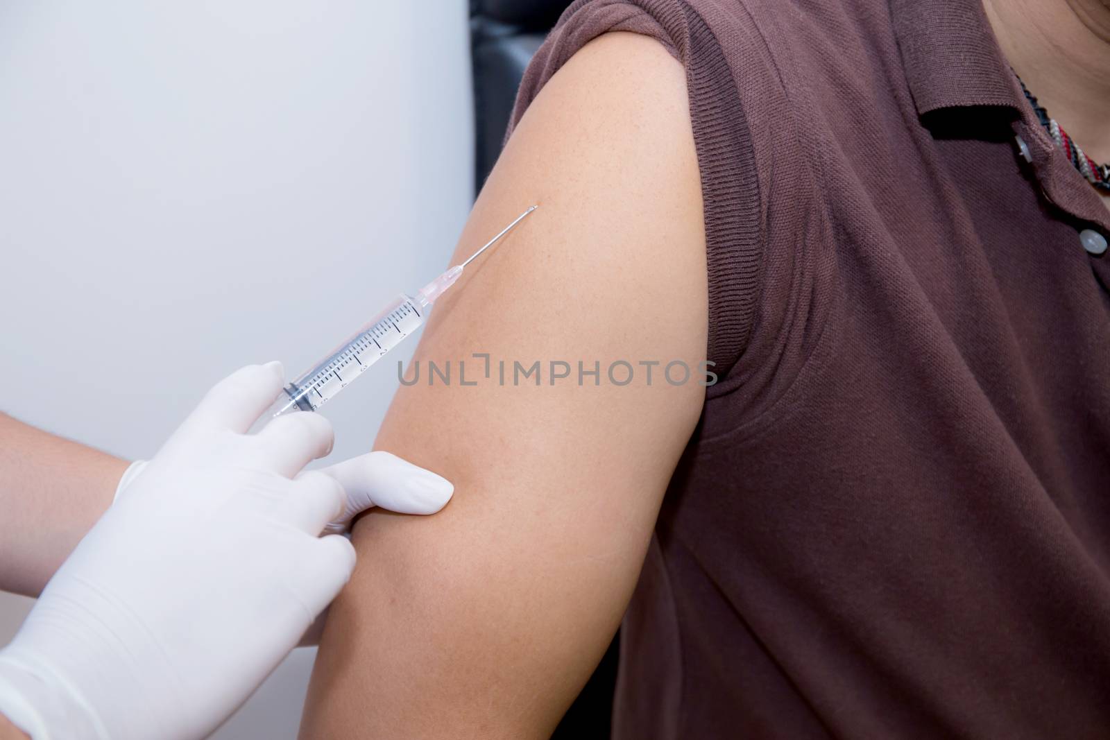 Close-up Of Doctor Injecting Patient With Syringe To Collect Blood