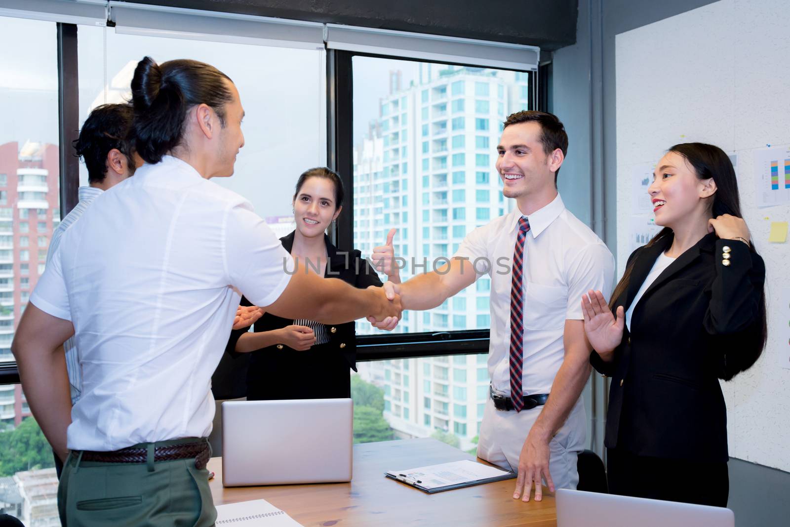 Business people shaking hands, finishing up a meeting. by nnudoo