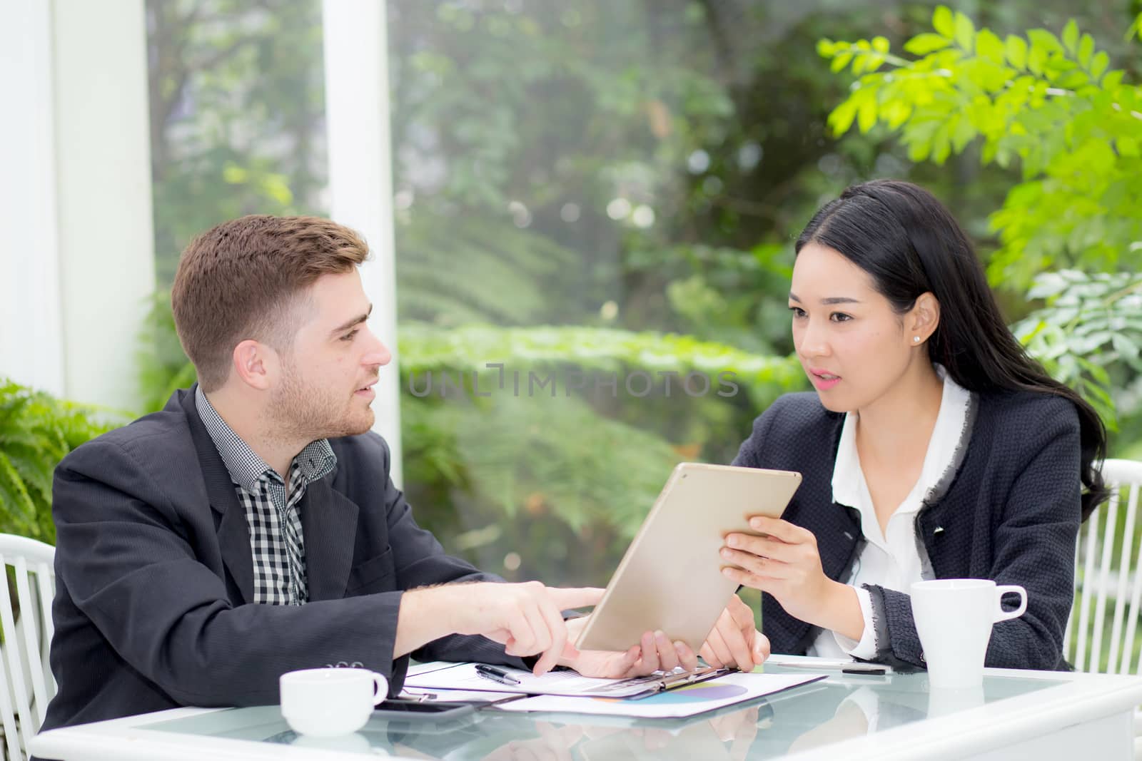 business man and woman people making meeting and looking at tablet for analyzing marketing working at office on desk.