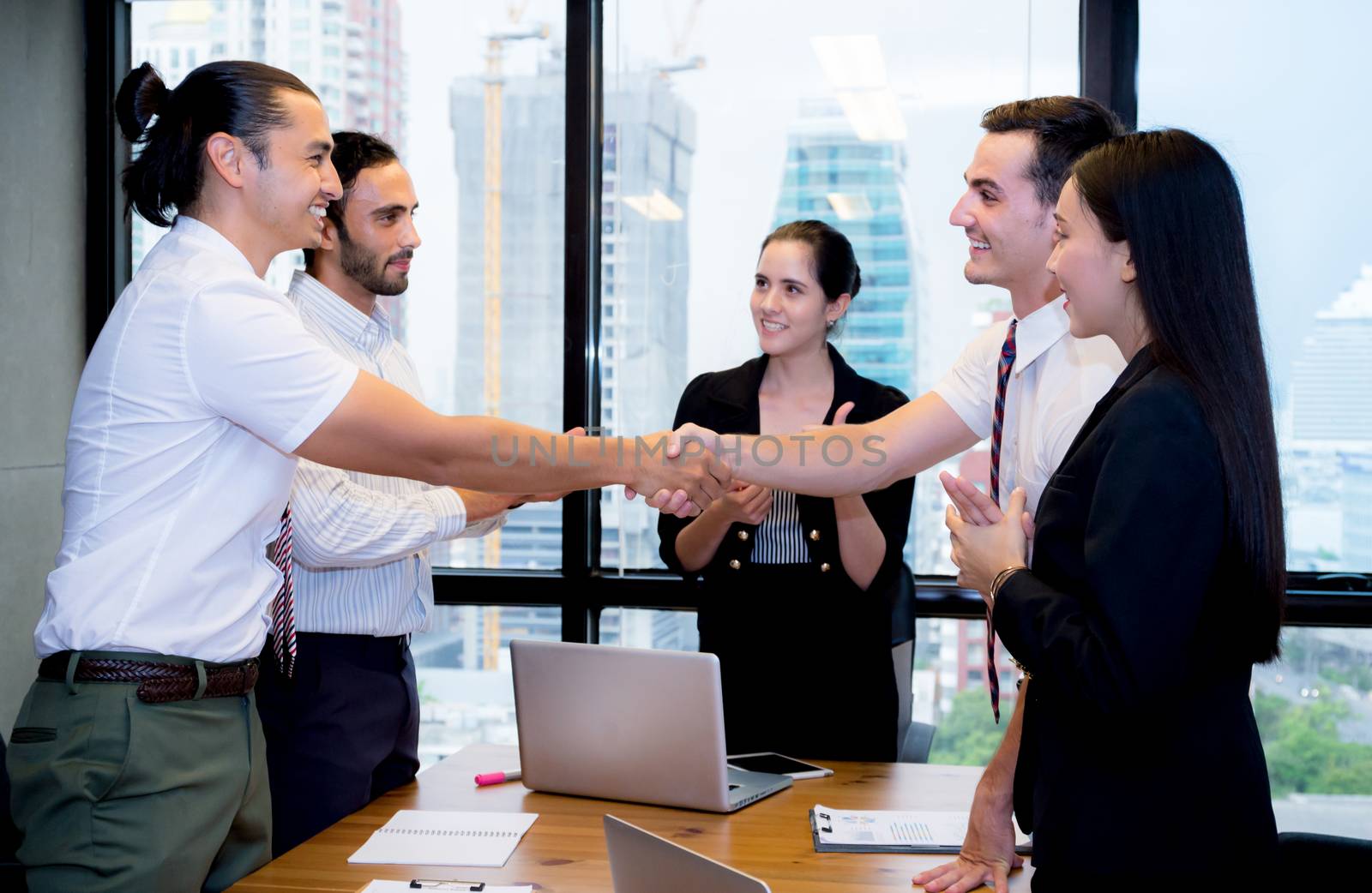 Business people shaking hands, finishing up a meeting. by nnudoo