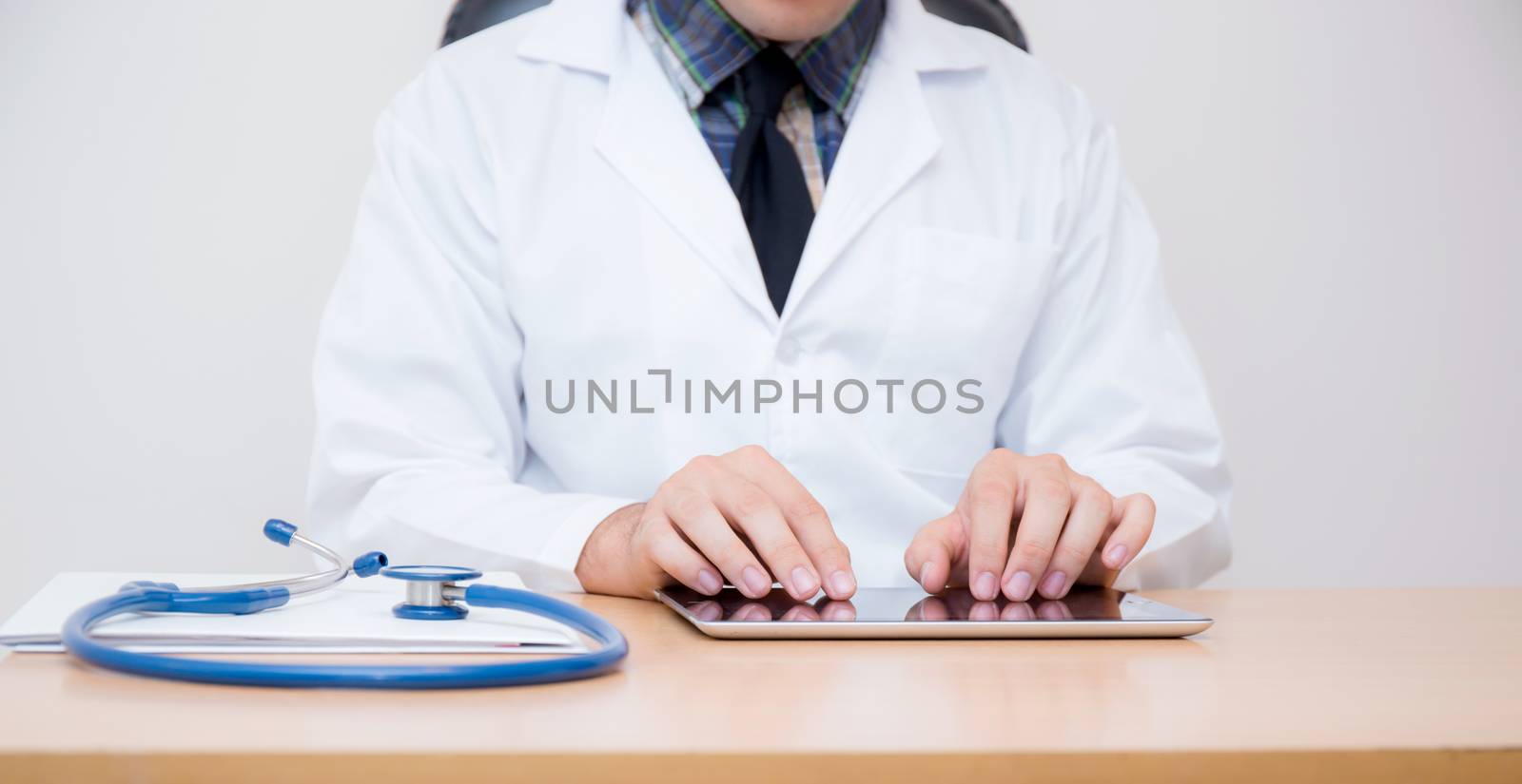 male doctor with tablet computer and stethoscope at the desk on white background.male doctor with tablet computer and stethoscope at the desk on white background.