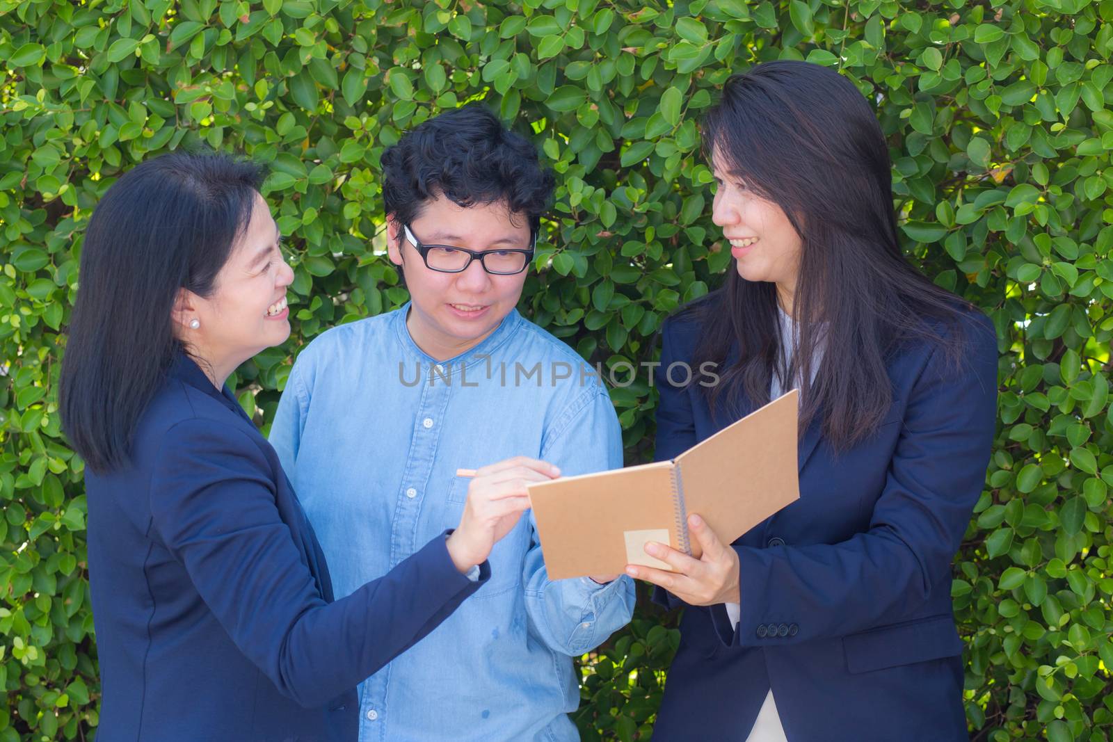 Businesswomen three people looking information on notebook or di by nnudoo