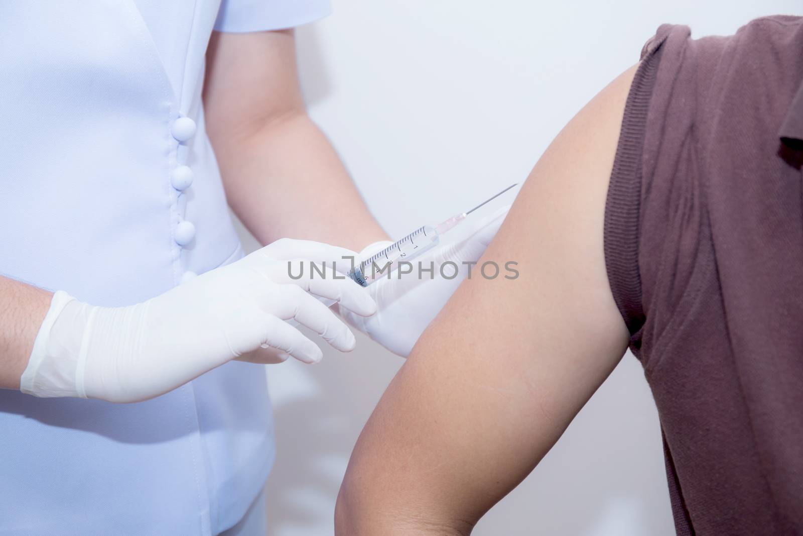 Close-up Of Doctor Injecting Patient With Syringe To Collect Blood