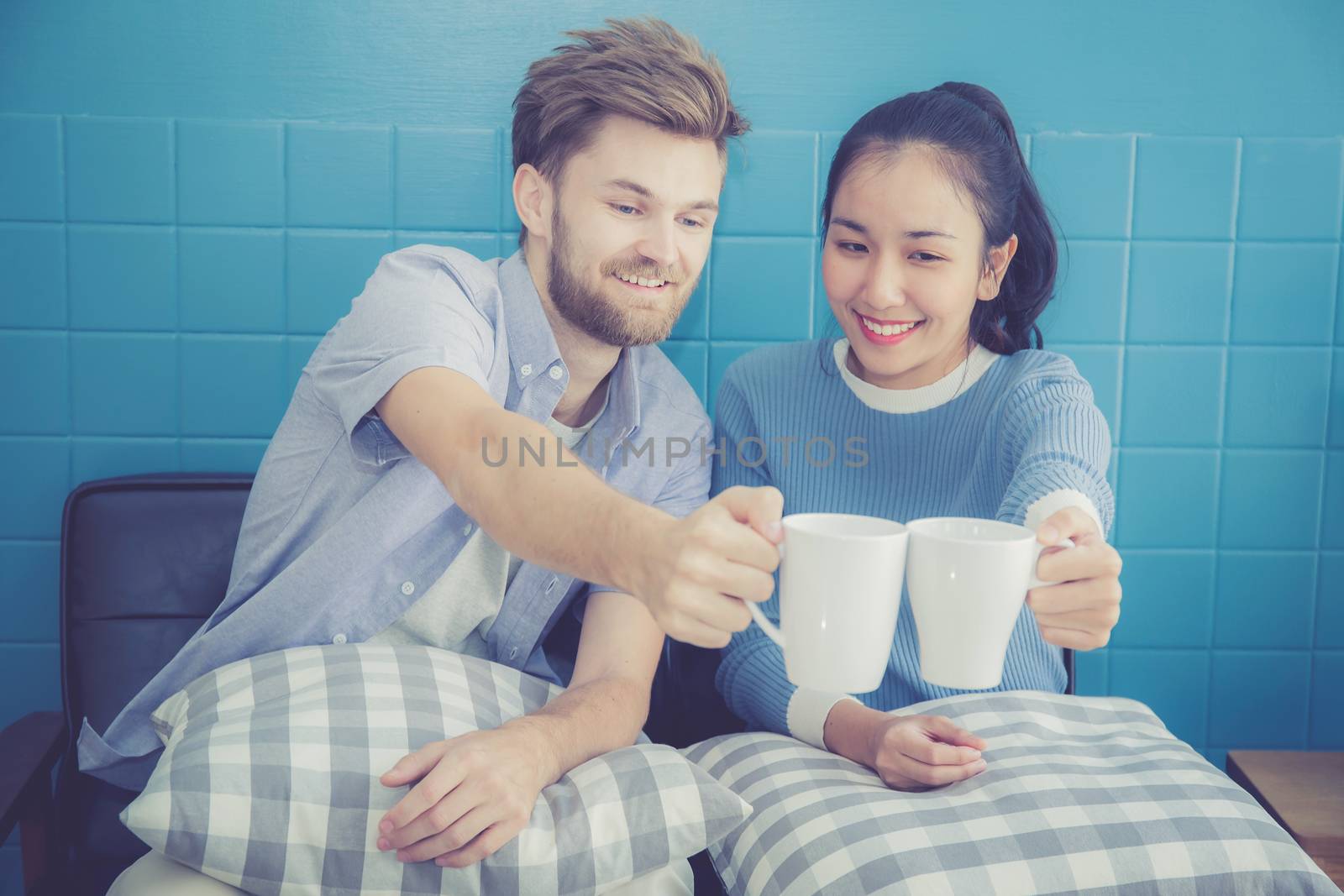 Two people couple in living room enjoy with drink coffee with su by nnudoo