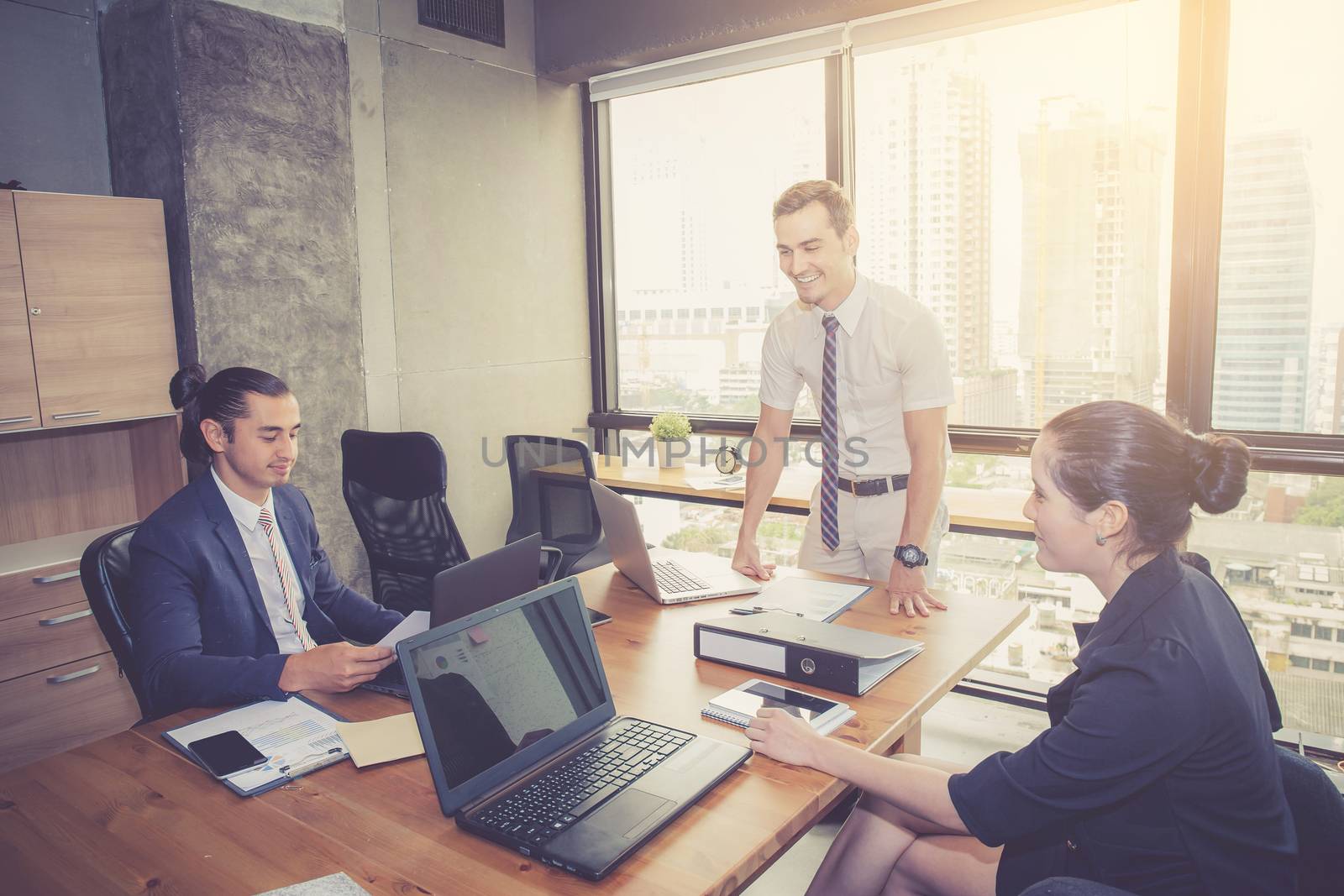 Businesspeople with leader discussing together in conference room during meeting at office.