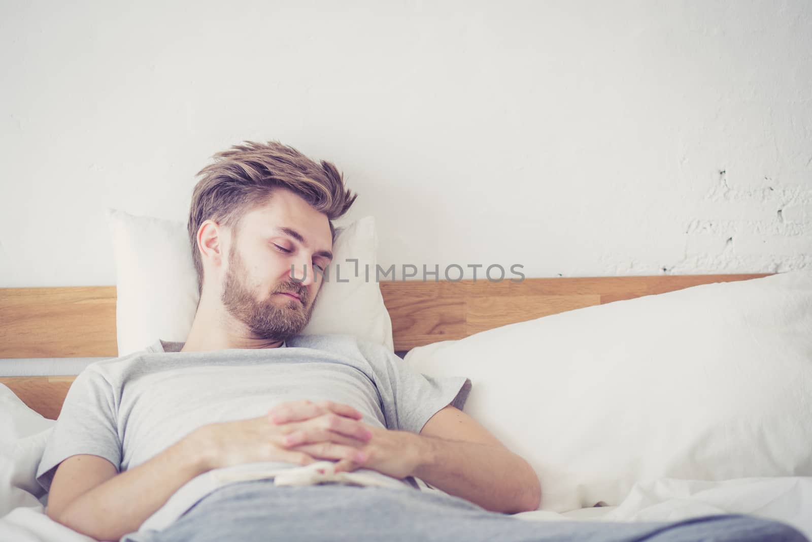 Handsome young american male sleeping in bed at home - healthcare concept.