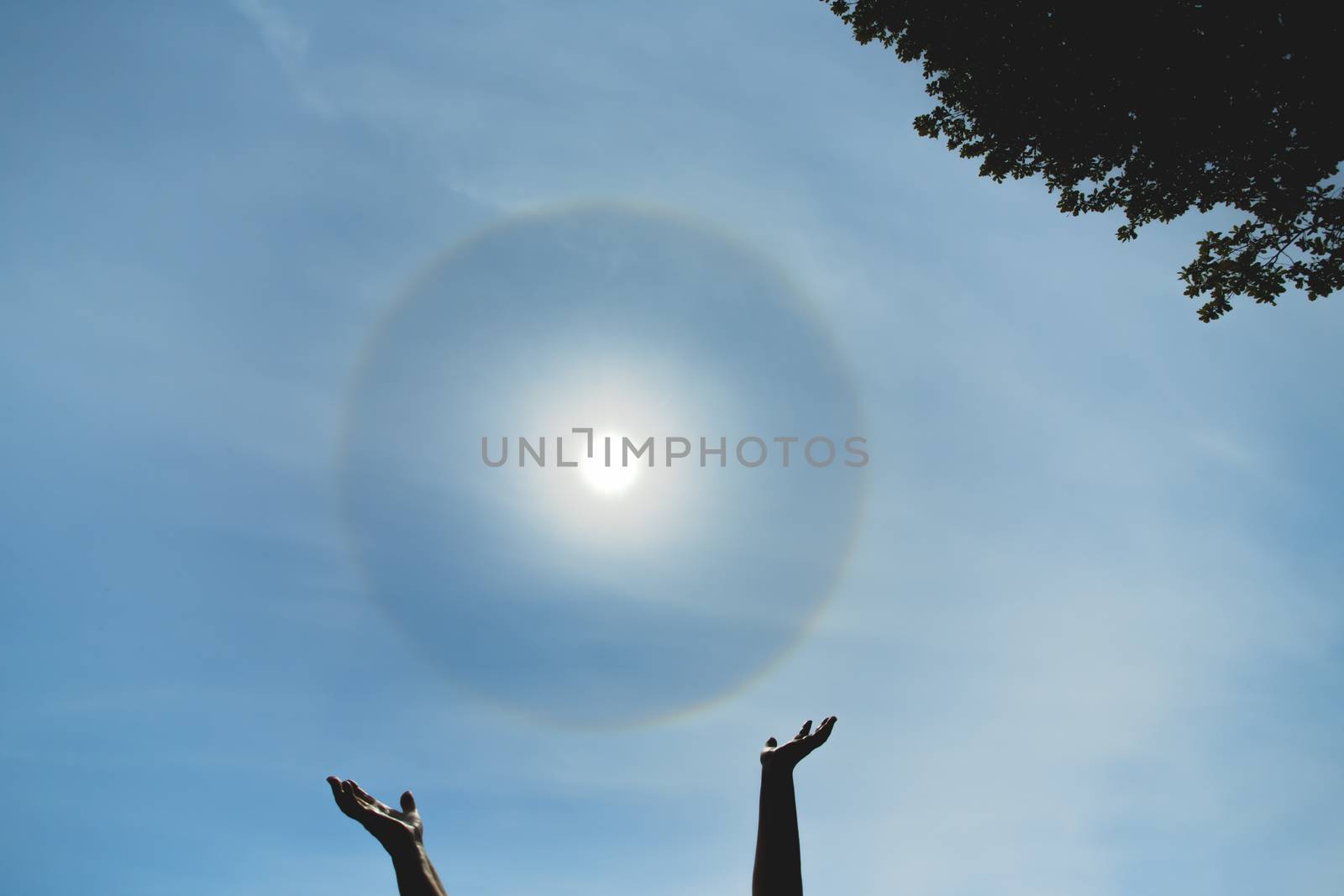 Reiki meditation. Sun in hands. Atmospheric optical effect circle around the sun on hot summer day. Atmospheric halo phenomenon around the sun by DmitrySteshenko