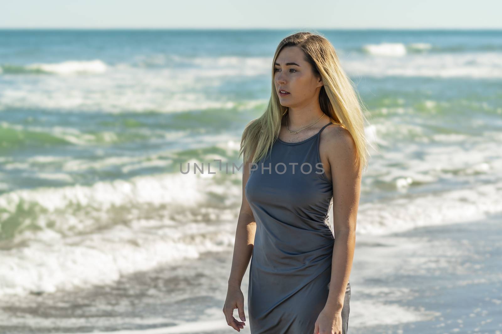 A gorgeous young blonde female enjoys a day at the beach alone