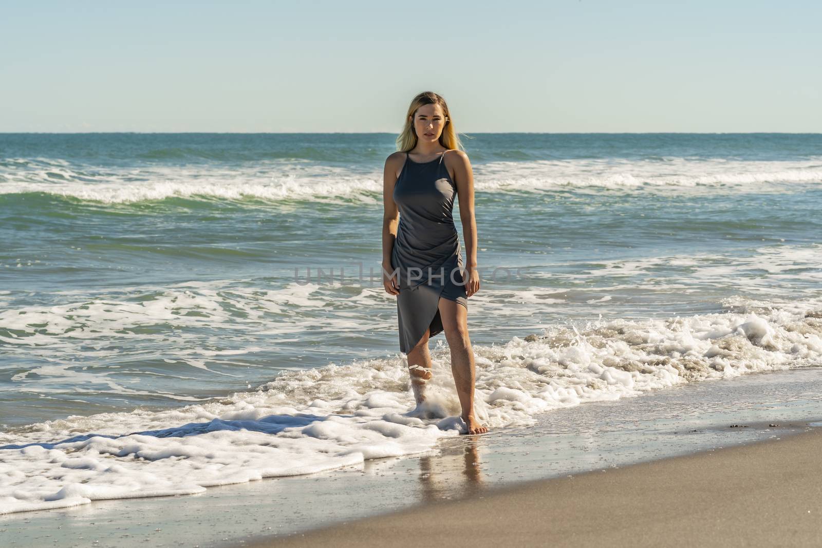 A gorgeous young blonde female enjoys a day at the beach alone