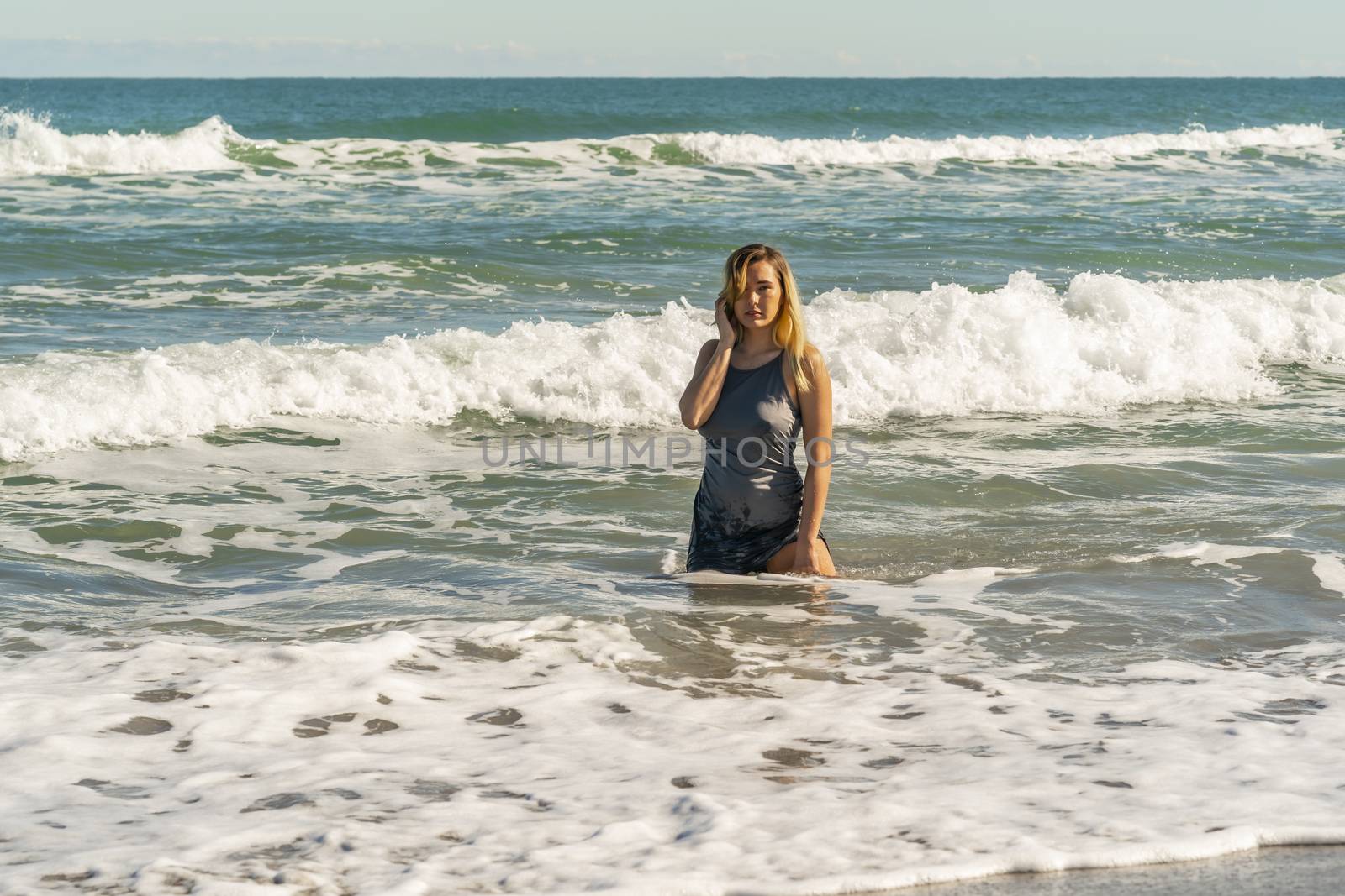 A gorgeous young blonde female enjoys a day at the beach alone