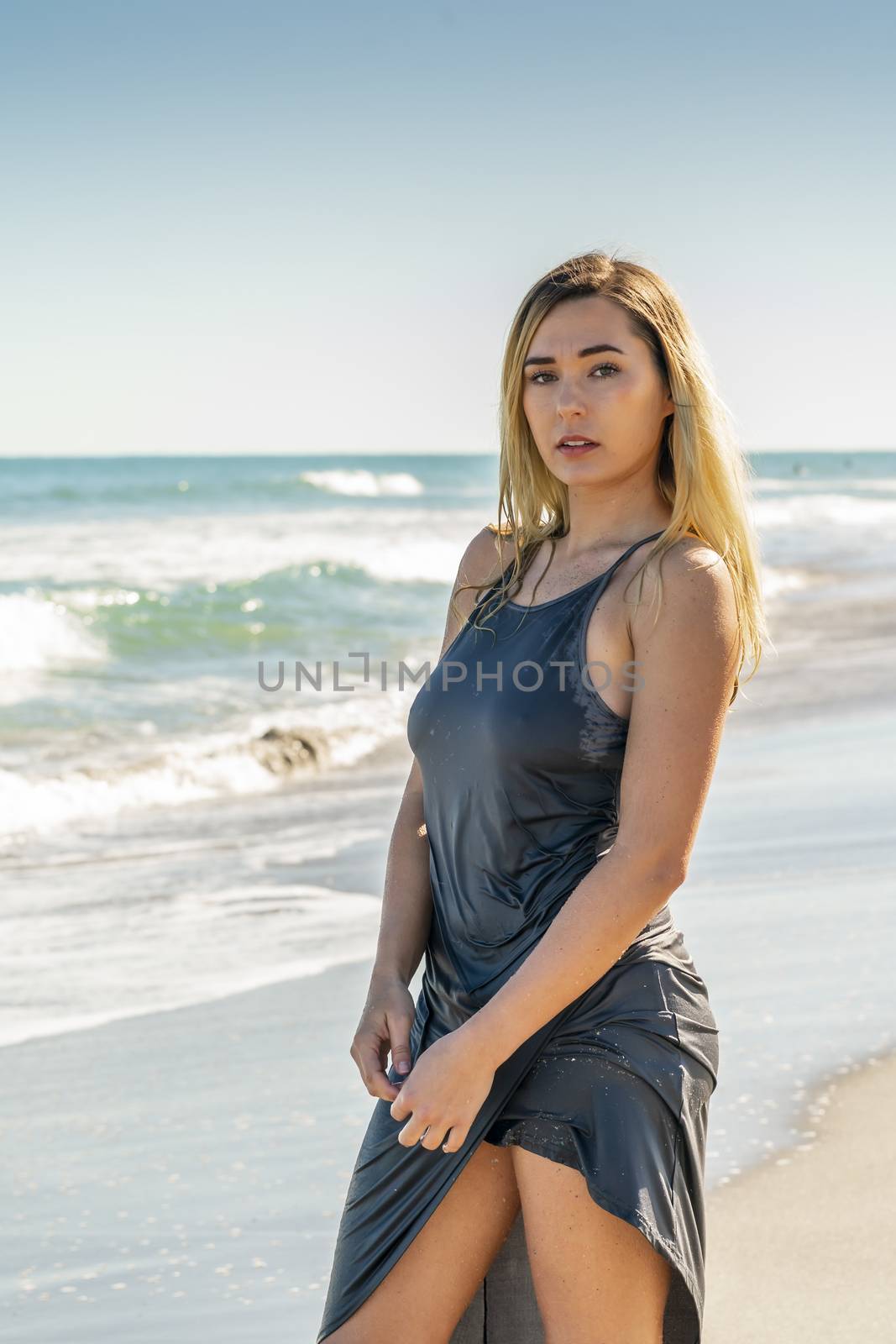 A gorgeous young blonde female enjoys a day at the beach alone