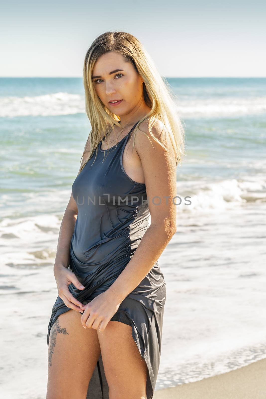 A gorgeous young blonde female enjoys a day at the beach alone