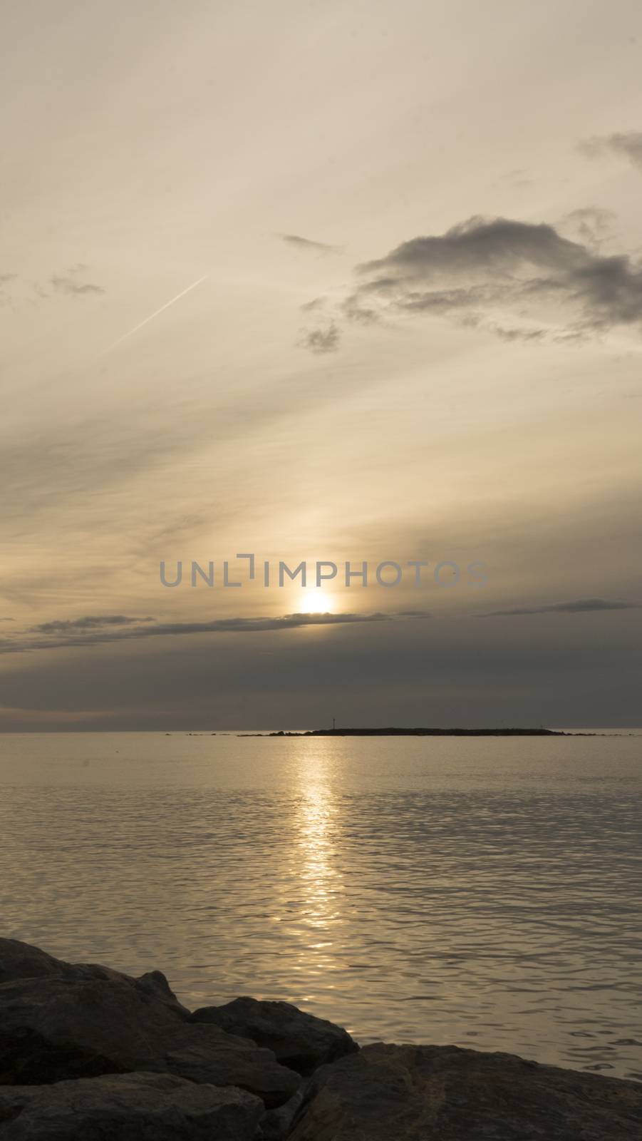 Emotional shot of a bay at sunrise or sunset in backlight with very cloudy sky