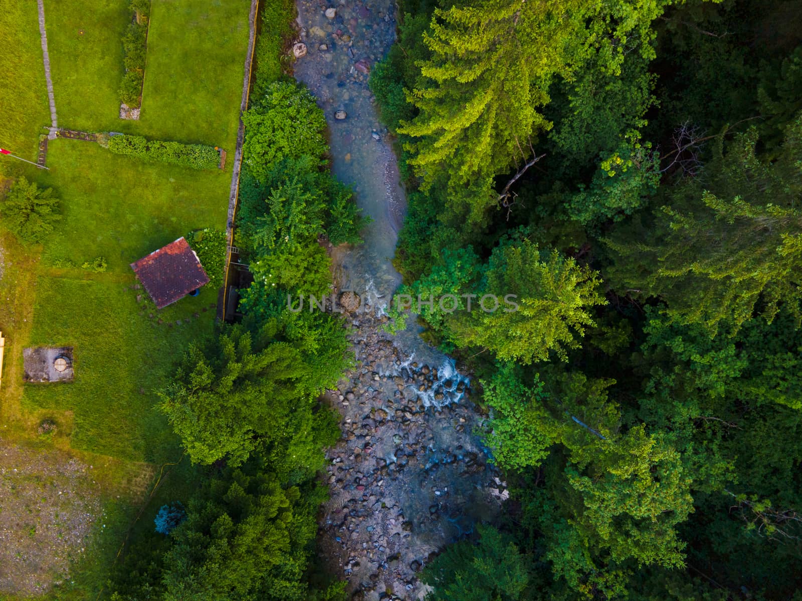 drone shot out in nature of river, bridge and green trees. Höllgrotte Switzerland