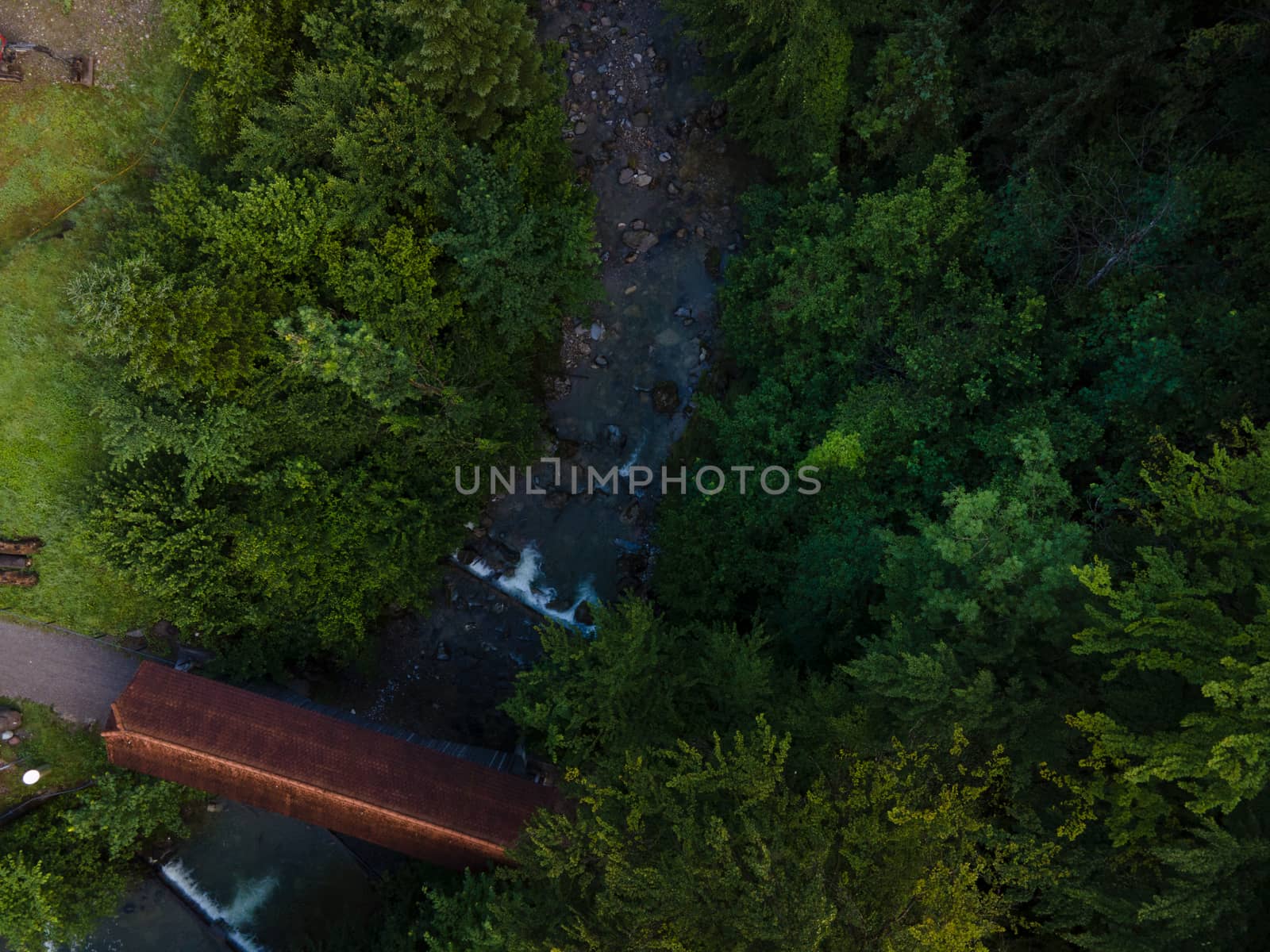 drone shot out in nature of river, bridge and green trees. Höllgrotte Switzerland