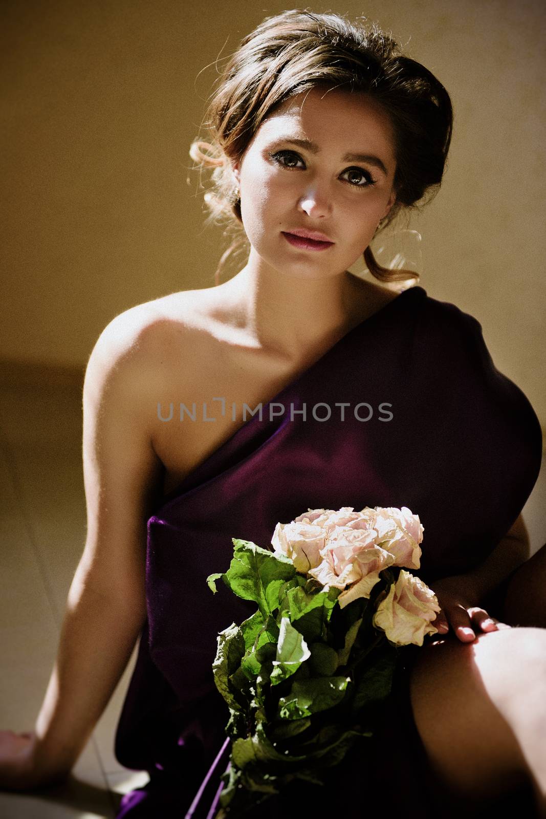 model girl in a blue dress in an art workshop with brushes, a palette and paintings