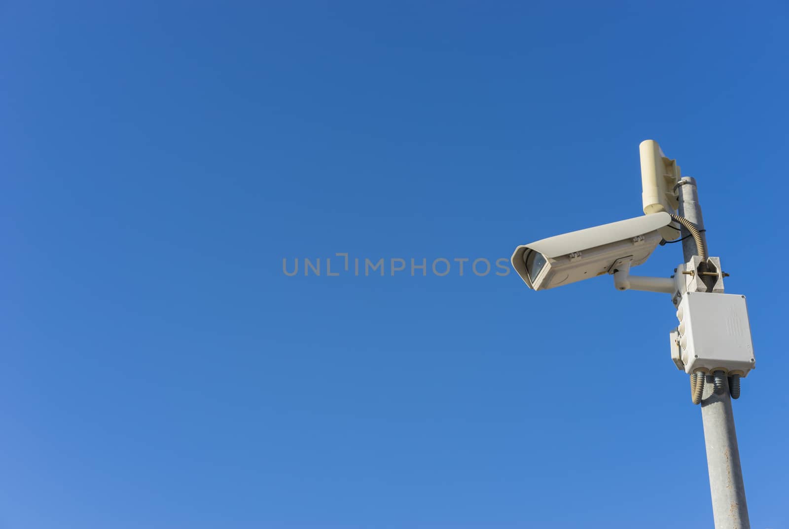 Security camera on pole with blue sky background and copy space