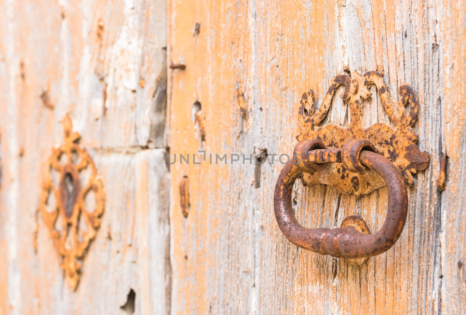 Closeup of an old door knocker of vintage wooden entrance front door
