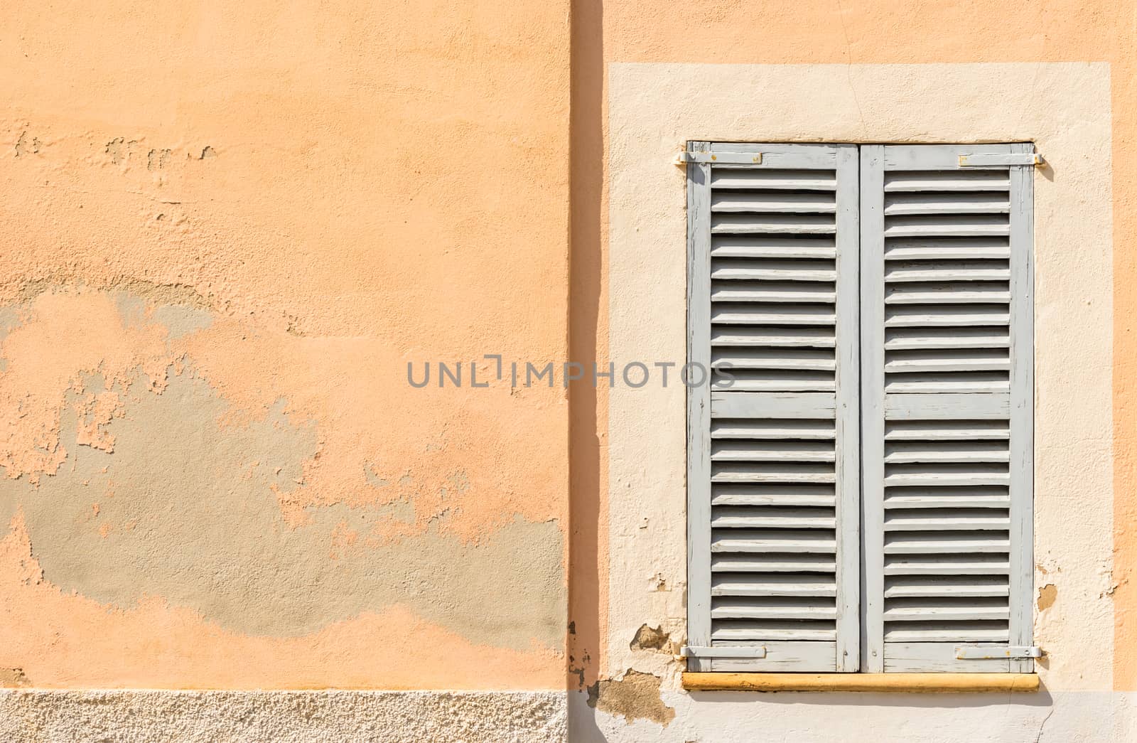Detail view of wooden window shutters and wall